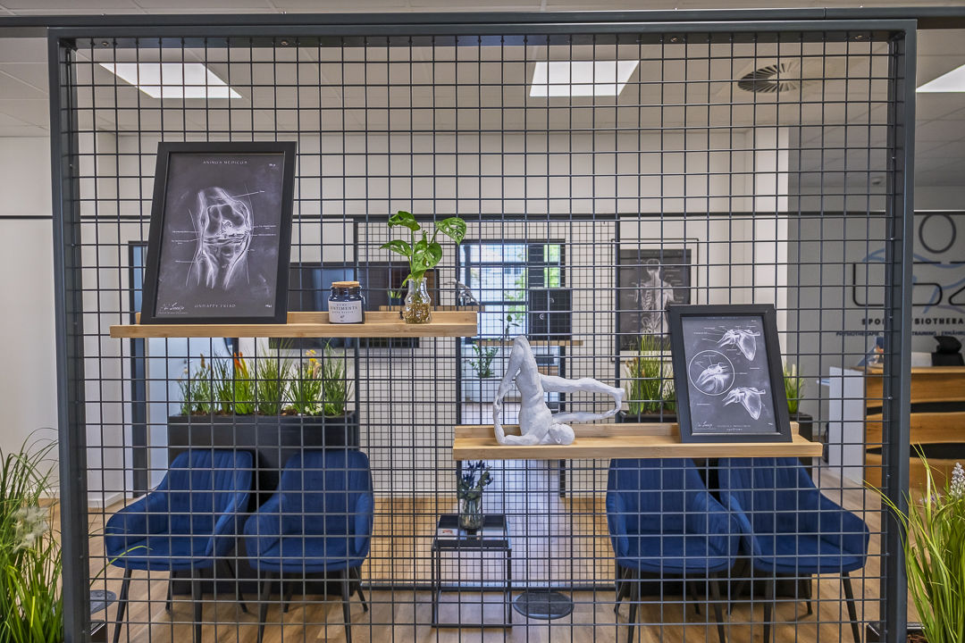 Sitzecke mit Anatomie-Kunst und Gitterwand-Raumteiler